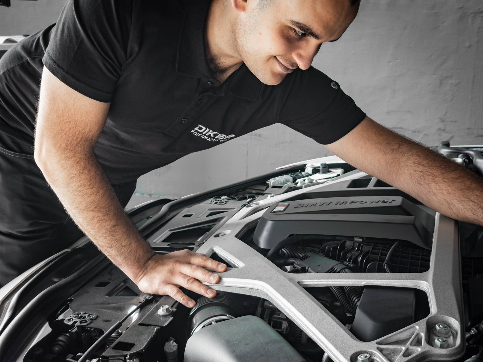 Mechaniker von Diker Fahrzeugtechnik prüft den Motorraum eines Fahrzeugs